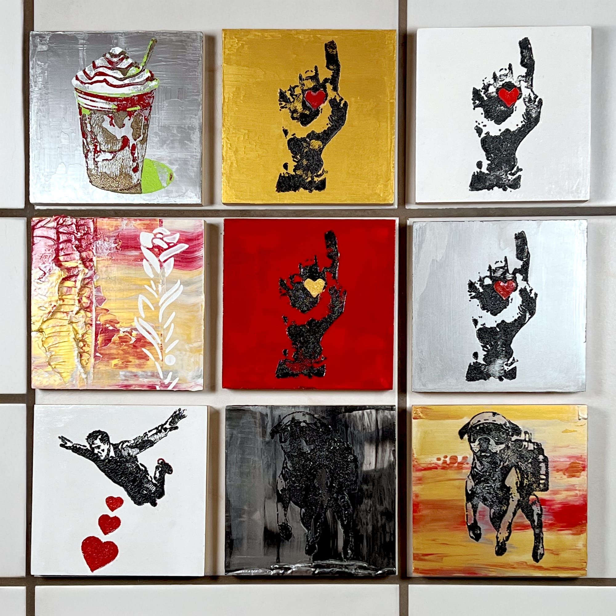 Grid of nine 6x6 acrylic paintings showing fists, dogs, a latte, and hearts—small works with big presence.